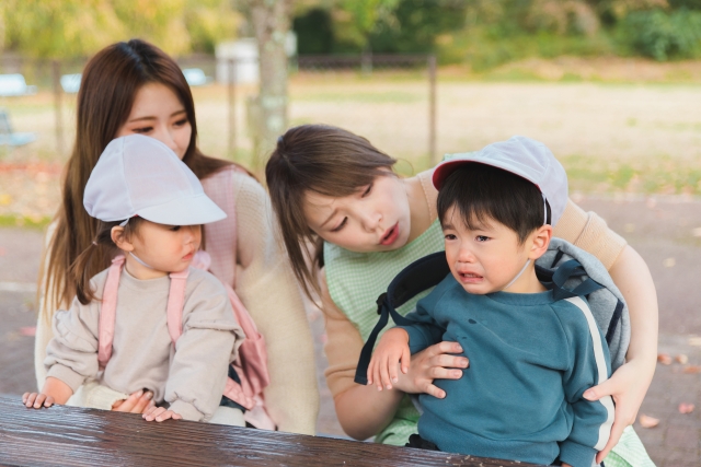 泣く子どもと保育士
